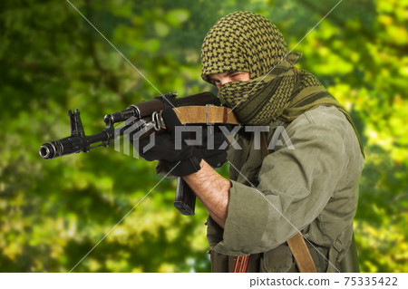 guerilla fighter firing AK 47 gun in jungle forest guerilla fighter firing AK 47 gun in jungle forest 75335422