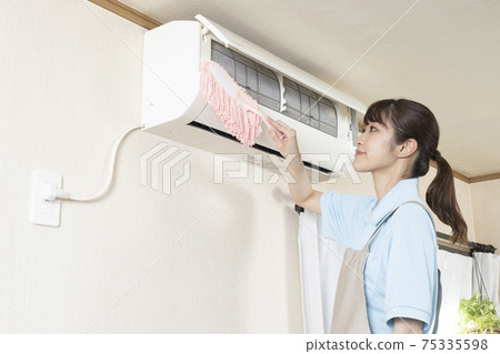 Female house cleaning worker cleaning the air conditioner with a handy mop 75335598
