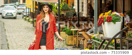 Woman is walking with suitcase 75335909