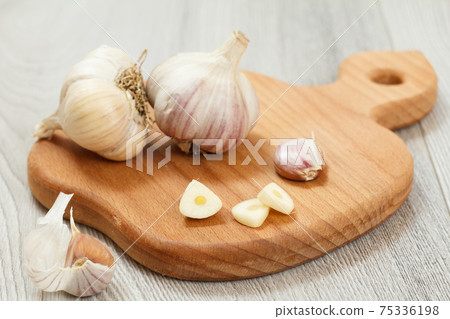 Ripe garlic heads on a wooden cutting board Ripe garlic heads on a wooden cutting board 75336198