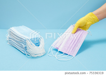 Female doctor in a glove holding medical masks in his hand. 75336319