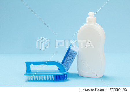 Bottle of dishwashing liquid, a sponge and a brushes on a blue background. 75336460
