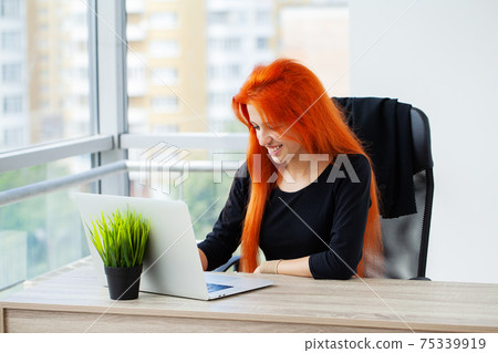 Pretty woman working on laptop in the office 75339919