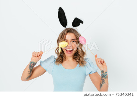 Funny happy young woman holding decorative Easter colored eggs Funny happy young woman holding decorative Easter colored eggs 75340341