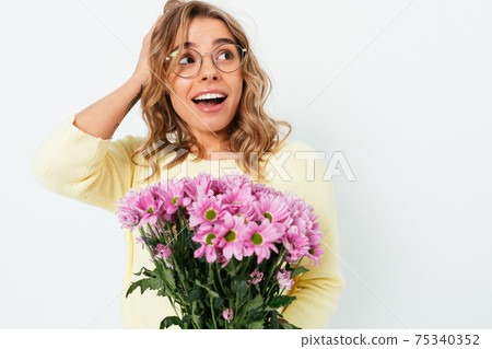 Amazed happy young woman wearing eyeglasses holding bouquet Amazed happy young woman wearing eyeglasses holding bouquet 75340352