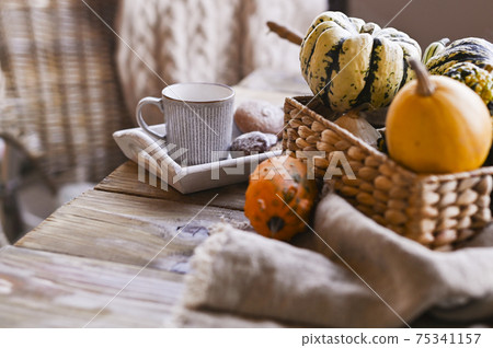Autumn, pumpkins, hot steaming cup of coffee on a wooden table background. Seasonal, morning coffee Autumn, pumpkins, hot steaming cup of coffee on a wooden table background. Seasonal, morning coffee 75341157