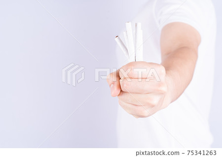 Male hand crushing cigarette. World no Tobacco and stop smoking day. 75341263