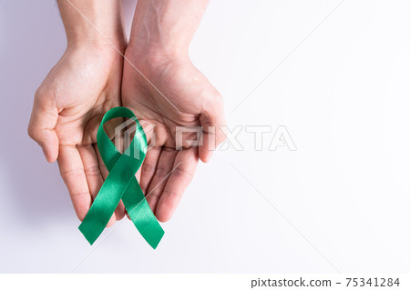 World kidney day, hands holding green ribbon awareness of kidney disease isolated white background. 75341284
