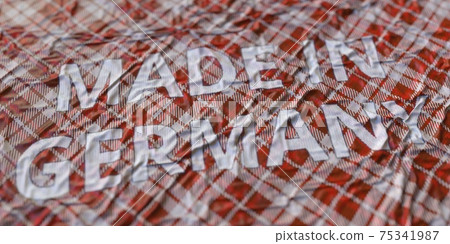 MADE IN GERMANY words printed on a cloth, national textile production conceptual 3d rendering 75341987