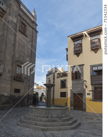 Square Plaza del pilar nuovo with fountain and Historic house museum of Christopher Columbus Casa de Colon at old town Vegueta in Las Palmas de Gran Canaria at sunny day. Canary Islands, Spain 75342334