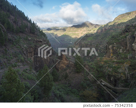 Scenic view of Tamadaba natural park with green hills, forest mountains and dam. Gran Canaria, Canary Islands, Spain Scenic view of Tamadaba natural park with green hills, forest mountains and dam. Gran Canaria, Canary Islands, Spain 75342358