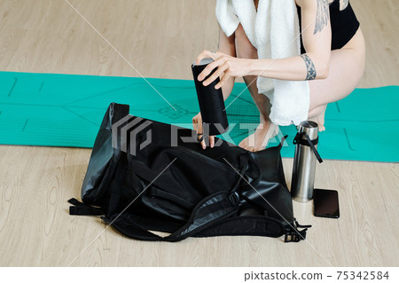 Woman packing gym bag 75342584