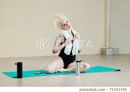 Fit woman sitting on mat 75342595