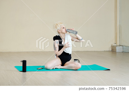 Fit woman drinking water 75342596