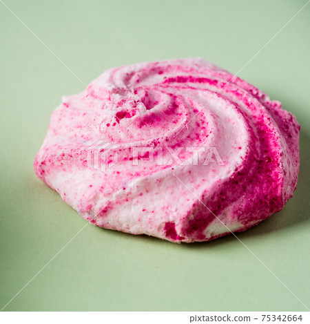 Homemade sweet colored meringue on green background.  .Dessert. Close up meringue photo 75342664