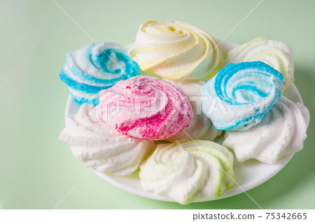 Homemade sweet colored meringue on green background. .Dessert. Homemade sweet colored meringue on green background. .Dessert. 75342665