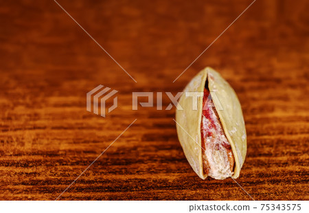 One Pistachio nuts a lot on wood macro image 75343575