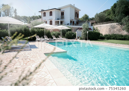 Pool with clear blue water on sunny day in residential the yard Pool with clear blue water on sunny day in residential the yard 75345260