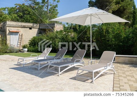 Sun beds on sunny day in the yard Sun beds on sunny day in the yard 75345266