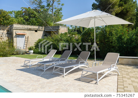 Sun beds on sunny day in the yard Sun beds on sunny day in the yard 75345267