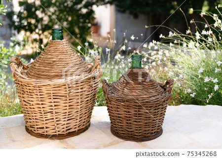 Due demijohn in a garden, made in Puglia Due demijohn in a garden, made in Puglia 75345268