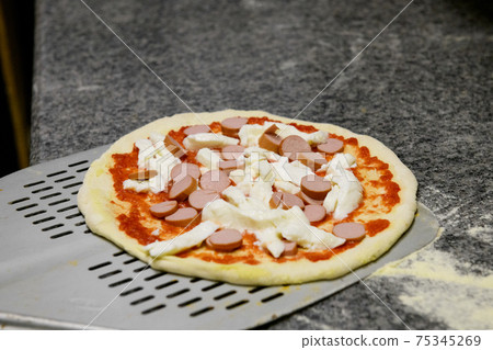 A fresh margherita pizza with sauseges on a shovel A fresh margherita pizza with sauseges on a shovel 75345269