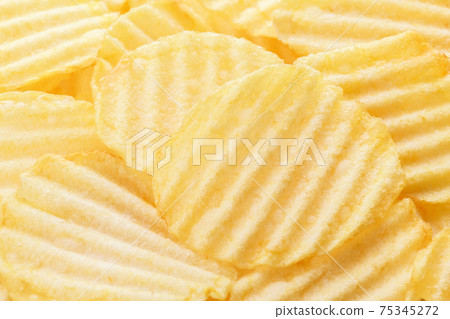 Yellow corrugated salted potato chips as food background Yellow corrugated salted potato chips as food background 75345272