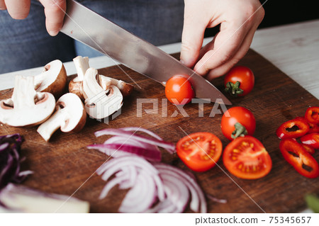 Woman preparing healthy vegetarian food in kitchen Woman preparing healthy vegetarian food in kitchen 75345657