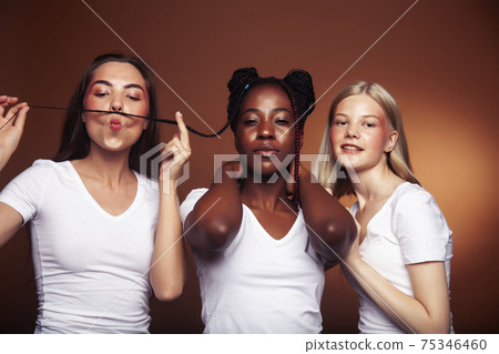 young pretty asian, caucasian, afro woman posing cheerful together on brown background, lifestyle diverse nationality people concept young pretty asian, caucasian, afro woman posing cheerful together on brown background, lifestyle diverse nationality people concept 75346460