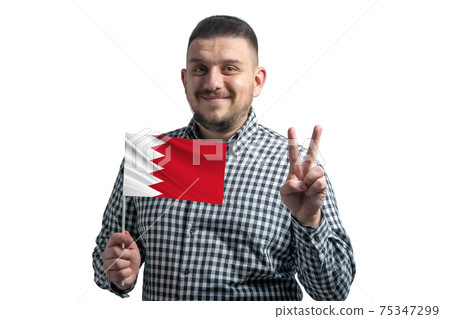 White guy holding a flag of Bahrain and shows two fingers isolated on a white background White guy holding a flag of Bahrain and shows two fingers isolated on a white background 75347299