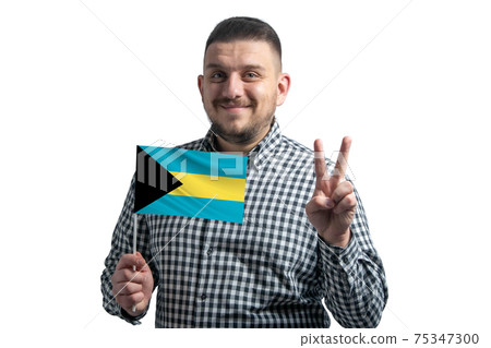 White guy holding a flag of Bahamas and shows two fingers isolated on a white background White guy holding a flag of Bahamas and shows two fingers isolated on a white background 75347300