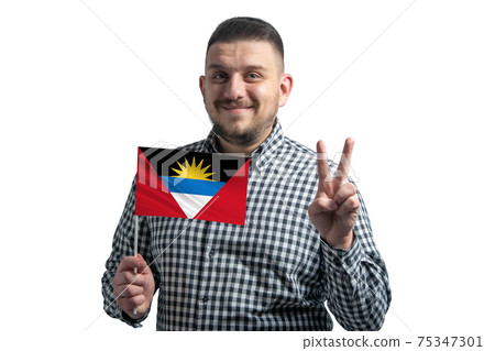 White guy holding a flag of Antigua and Barbuda and shows two fingers isolated on a white background White guy holding a flag of Antigua and Barbuda and shows two fingers isolated on a white background 75347301