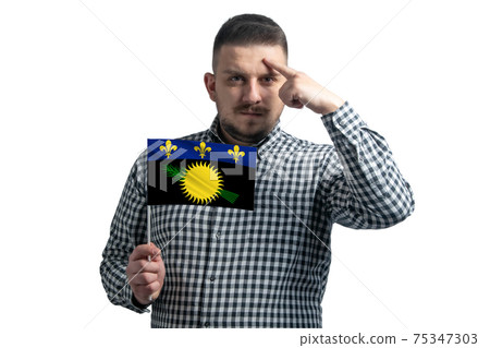 White guy holding a flag of Guadeloupe and a finger touches the temple on the head isolated on a white background White guy holding a flag of Guadeloupe and a finger touches the temple on the head isolated on a white background 75347303