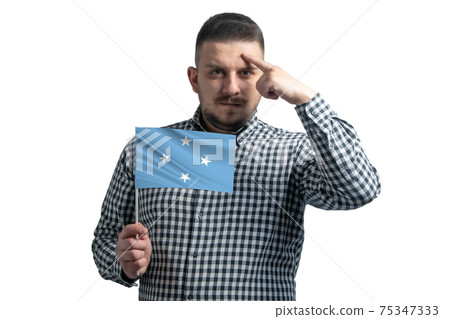 White guy holding a flag of Federated States of Micronesia and a finger touches the temple on the head isolated on a white background White guy holding a flag of Federated States of Micronesia and a finger touches the temple on the head isolated on a white background 75347333
