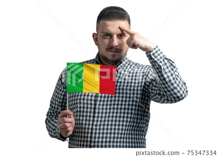 White guy holding a flag of Mali and a finger touches the temple on the head isolated on a white background White guy holding a flag of Mali and a finger touches the temple on the head isolated on a white background 75347334