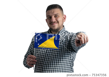 White guy holding a flag of Tokelau and points forward in front of him isolated on a white background 75347356