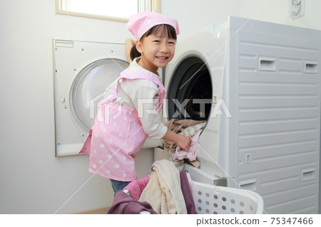 A 5-year-old girl helping to wash clothes 75347466