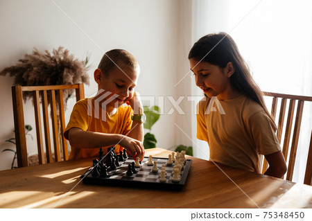 Kids having great time together playing chess Kids having great time together playing chess 75348450