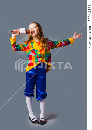 Little singer girl with microphone over grey background 75348538
