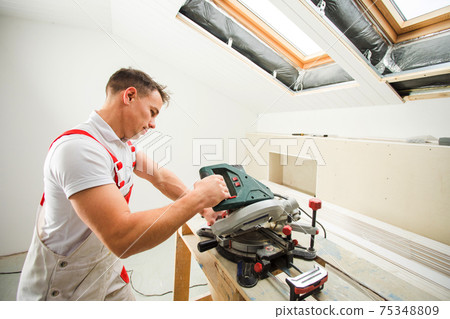 the man uses special tool for cut of boards 75348809