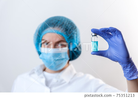 Doctor in gloves and mask holds bottle with vaccine, medicine Doctor in gloves and mask holds bottle with vaccine, medicine 75351213