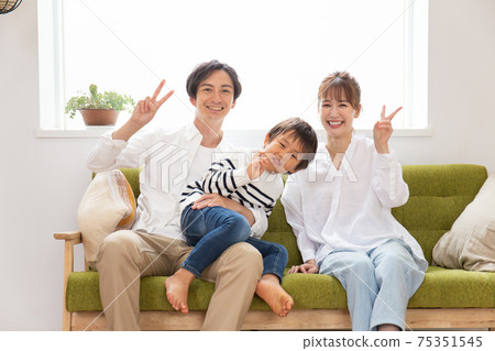 Young family signing peace on the couch 75351545