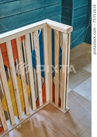 Multicolored wooden stair railings of the second floor in a modern wooden house 75351618