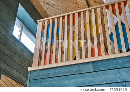 Multicolored wooden stair railings of the second floor in a modern wooden house 75351619