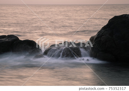 Long exposure silky smooth saltwater foam and rock formation in the evening, 75352317