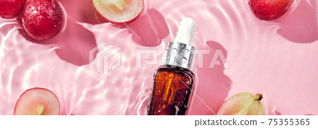 Skincare cosmetic product, grapes and water splashes on pink Banner. Organic cosmetics with grape seed oil and herbal ingredients. Zero Waste Winemaking 75355365