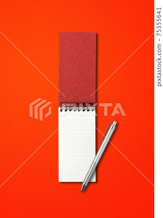 Blank open spiral notebook and pen isolated on red 75355641