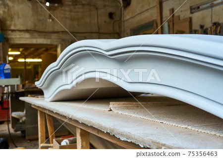 Joinery. Carved crown molding of a classical wardrobe. Furniture manufacture Joinery. Carved crown molding of a classical wardrobe. Furniture manufacture 75356463