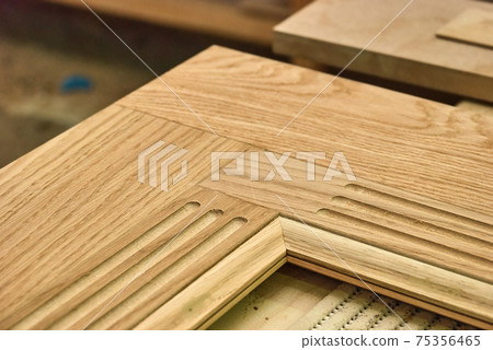 Carved wooden door frame on workbench in workshop closeup Carved wooden door frame on workbench in workshop closeup 75356465