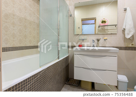 Bathroom interior, the bathroom is separated from the washbasin by a glass partition Bathroom interior, the bathroom is separated from the washbasin by a glass partition 75356488